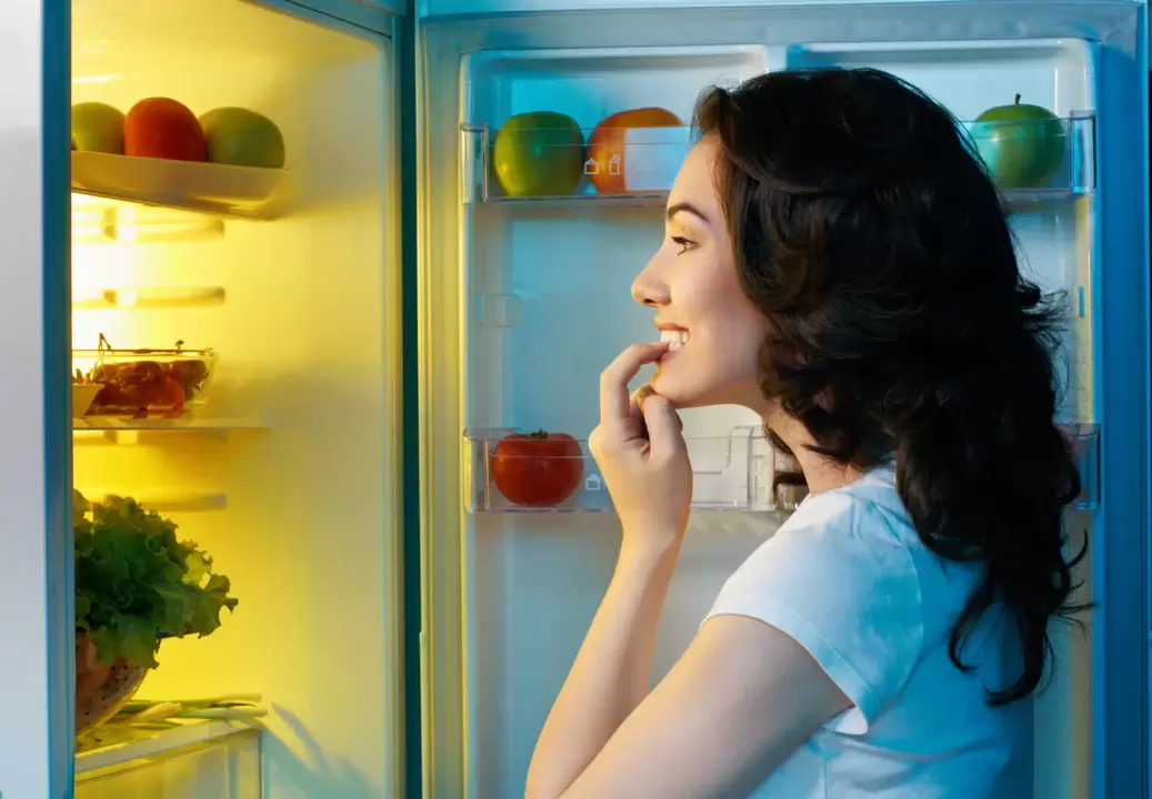 dievča vyzerá v chladničke počas rýchleho chudnutia